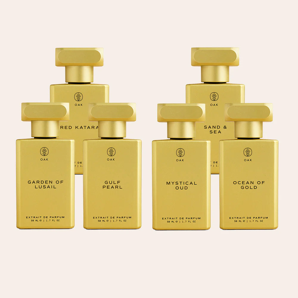 a group of five bottles of perfume on a white background