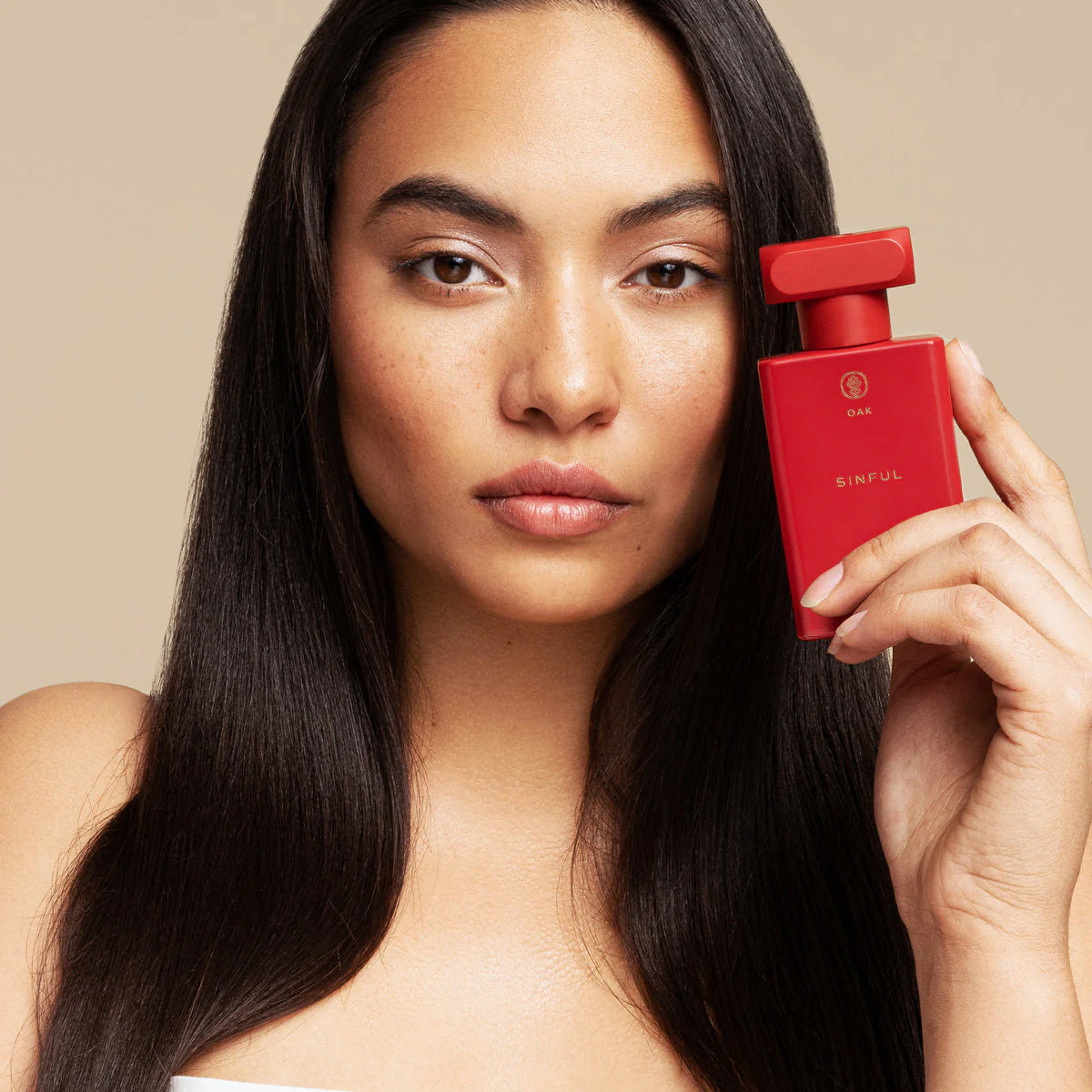 a woman holding a red object in front of her face
