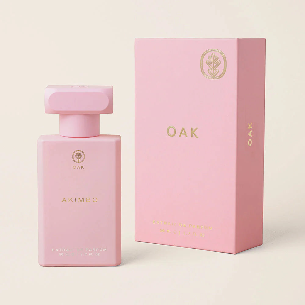 a pink bottle of perfume next to a pink box